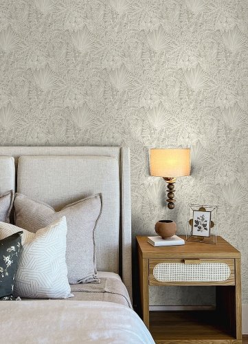 A Street Prints Vita Taupe Wallpaper shown in a bedroom with earthy tropical leaf and botanical style