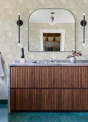 A Street Prints Vita Taupe Wallpaper styled in a modern living room with neutral tropical leaf pattern