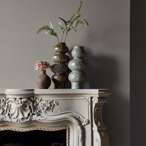 Fireplace wall painted in Abigail Ahern Anise Greige with calm, organic décor
