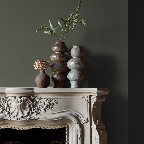 Fireplace wall painted in Abigail Ahern Desert Saltbush with calming, desert-inspired decor