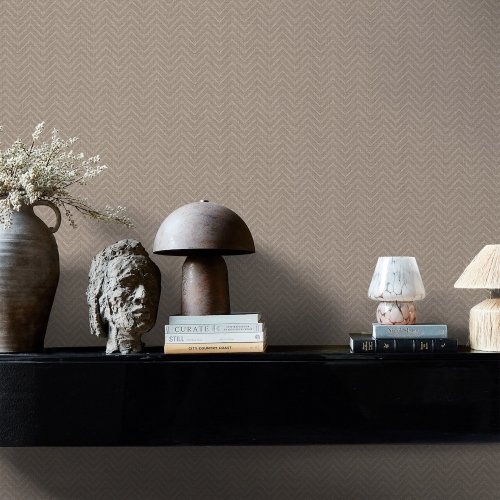 Second room view of Abigail Ahern Herringbone Weave Praline wallpaper with warm, layered decor