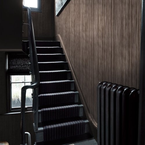 Room styled with Abigail Ahern Linear Luxe Deep Greige wallpaper in a warm, modern setting