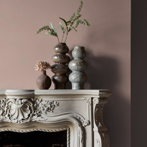 Fireplace wall painted in Abigail Ahern Monterey Blush with soft, warm-toned décor