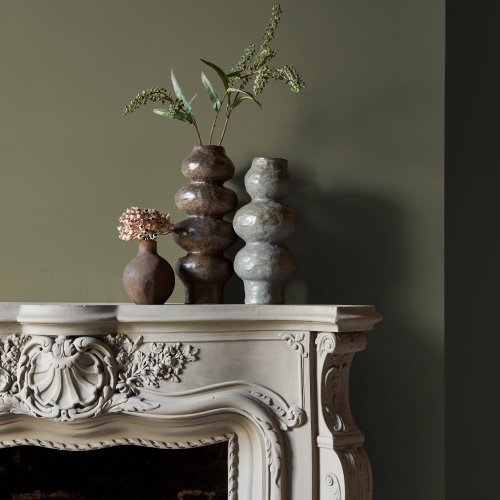 Fireplace wall painted in Abigail Ahern Neptune Grass with cosy, layered textures