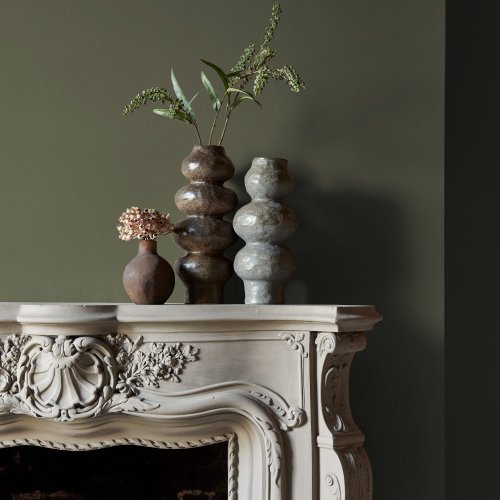 Fireplace wall painted in Abigail Ahern Seagrass Meadow with rustic, grounded decor