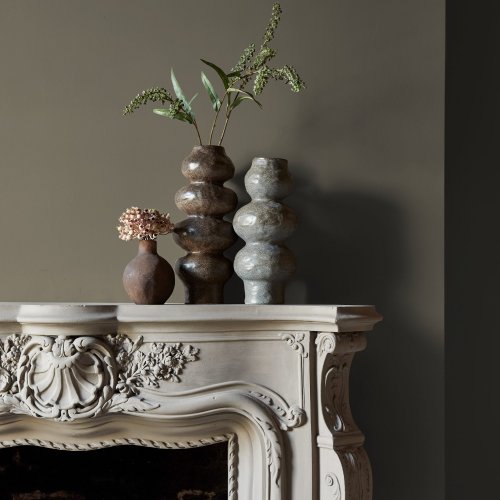 Fireplace wall painted in Abigail Ahern Wild Millet with earthy, modern decor