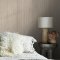 Room styled with Abigail Ahern Linear Luxe Deep Greige wallpaper in a warm, modern setting