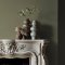 Fireplace wall painted in Abigail Ahern Neptune Grass with cosy, layered textures