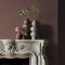 Fireplace wall painted in Abigail Ahern Raku Clay with ceramic accents and muted decor