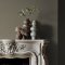 Fireplace wall painted in Abigail Ahern Wild Millet with earthy, modern decor